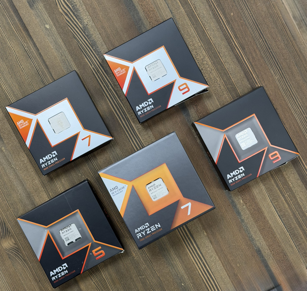 Коробки процессоров AMD Ryzen 5 9600X, Ryzen 7 7800X3D, Ryzen 7 9800X3D, Ryzen 9 9950X3D и Ryzen 9 серии 9000 на столе — вид сверху